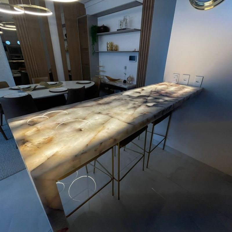Sala de jantar com bancada em ônix retroiluminado